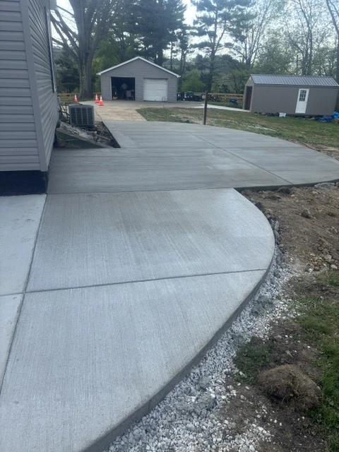 New concrete driveway apron leading into a residential garage