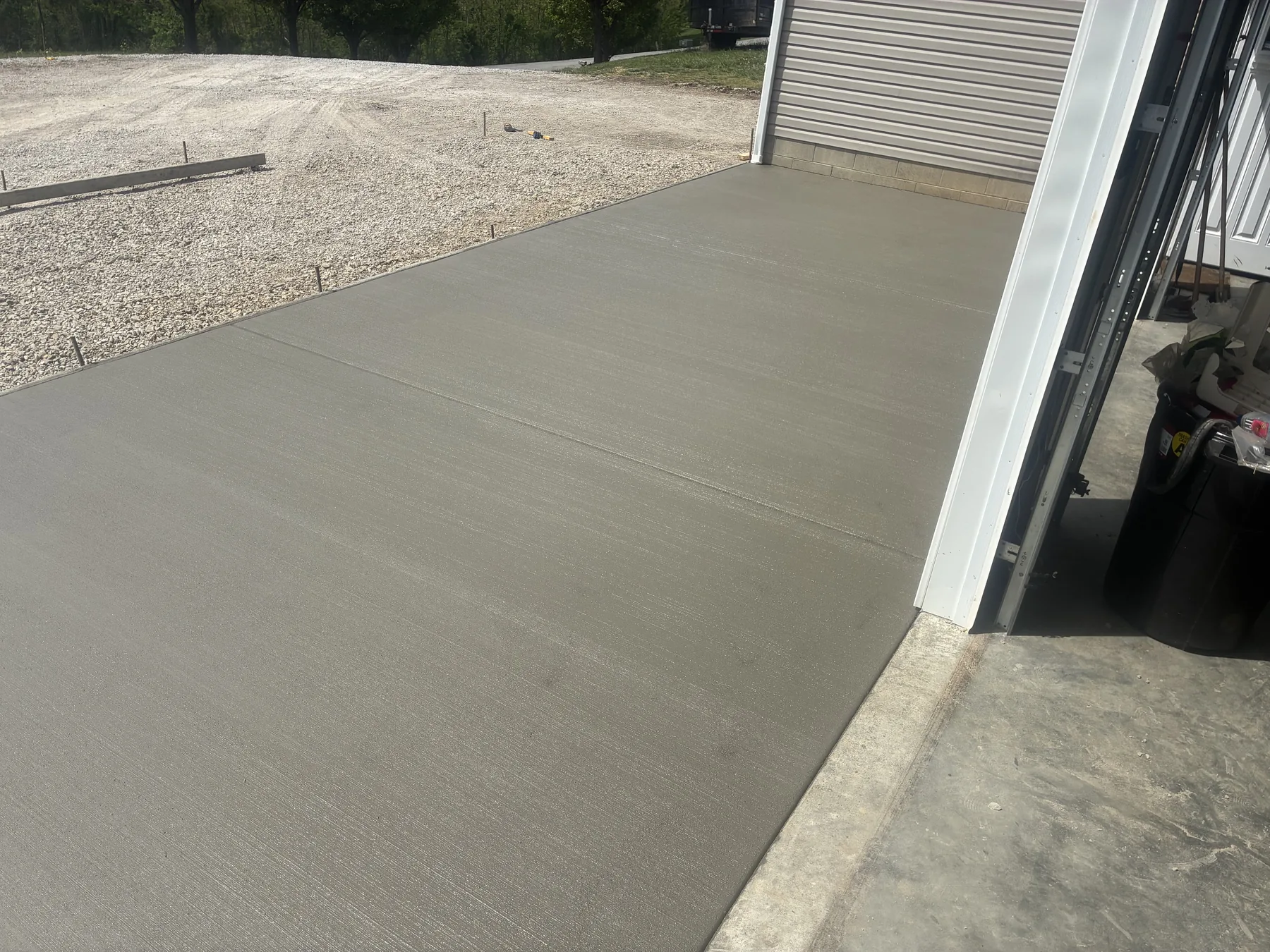 Large finished concrete pad spanning multiple residential garage bays