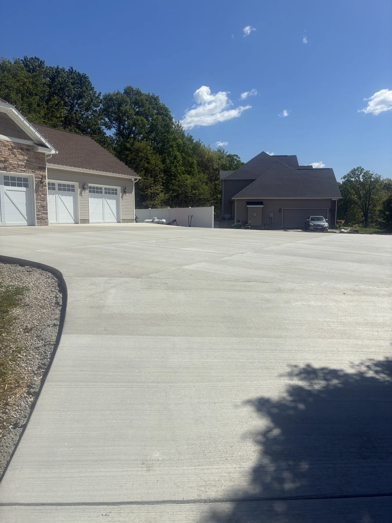 Large finished concrete parking apron connecting a home and detached garage