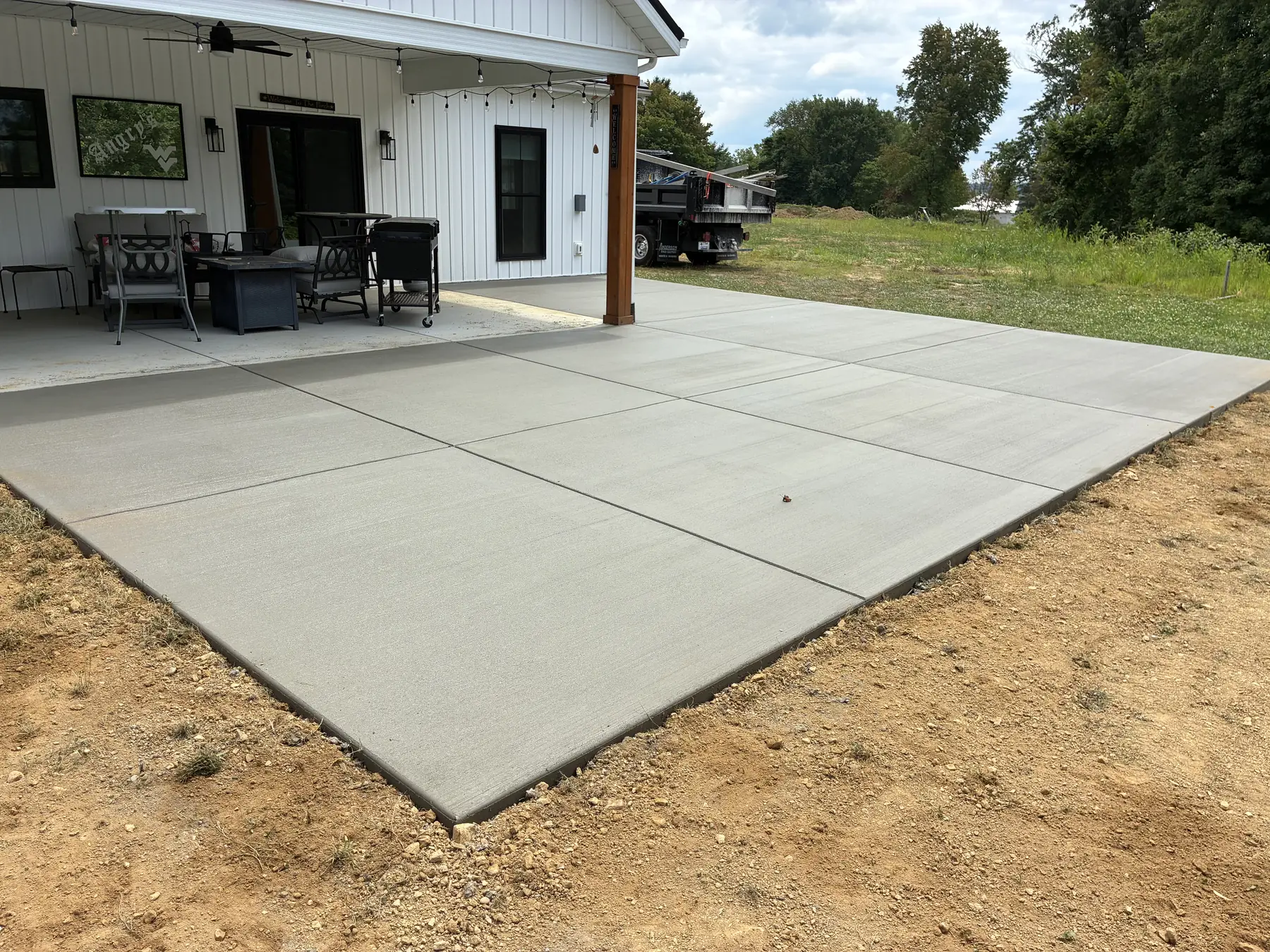 Broom-finished concrete patio extending from a covered porch