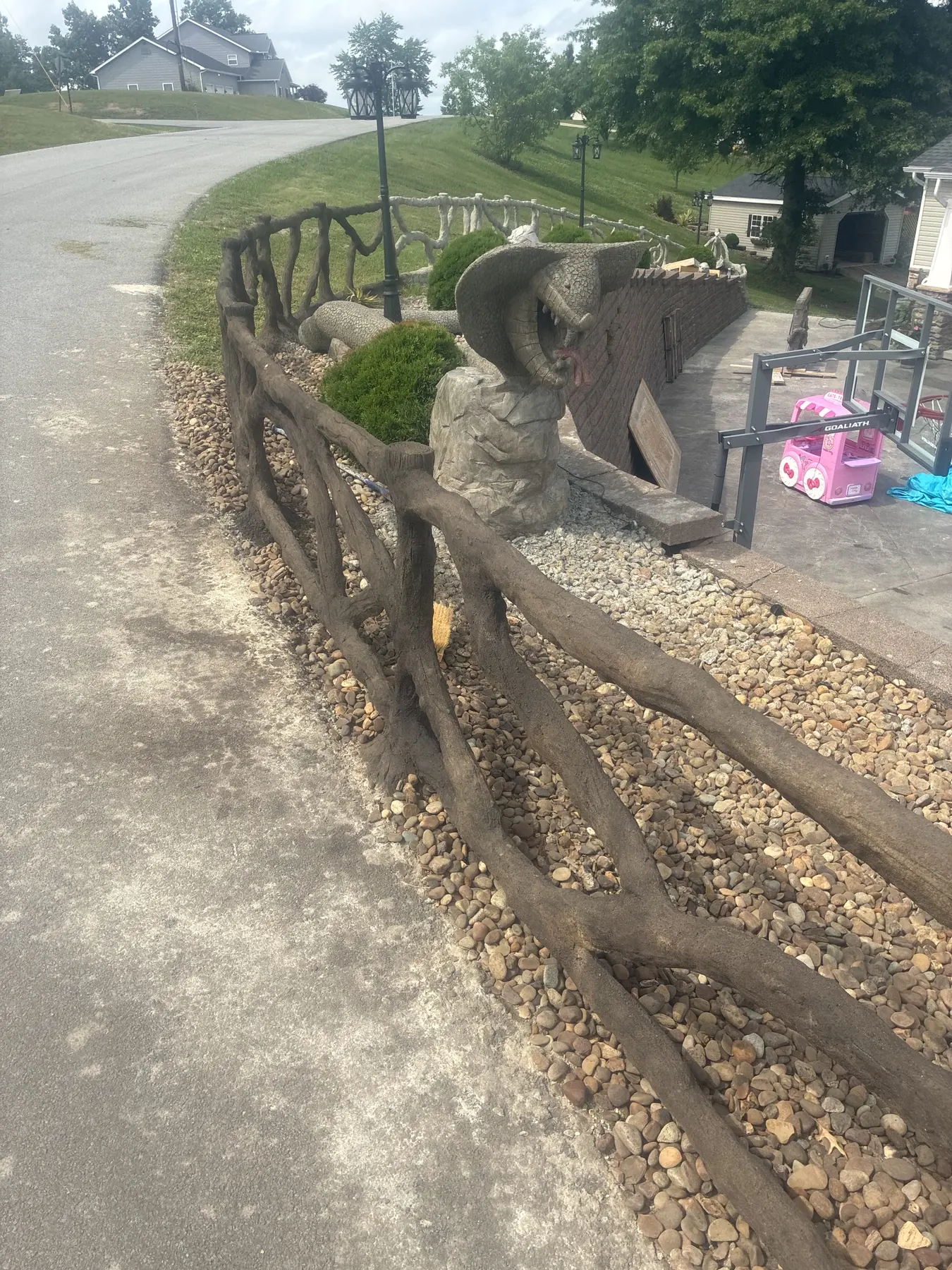 Decorative concrete rail fence bordering a landscaped residential property