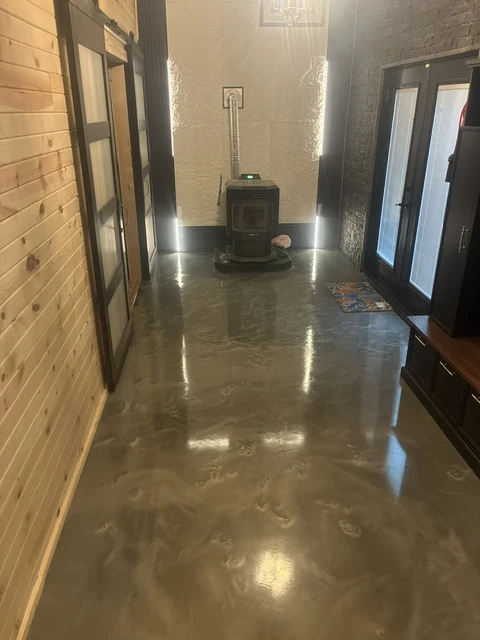 Glossy dark metallic epoxy floor extending through an interior hallway
