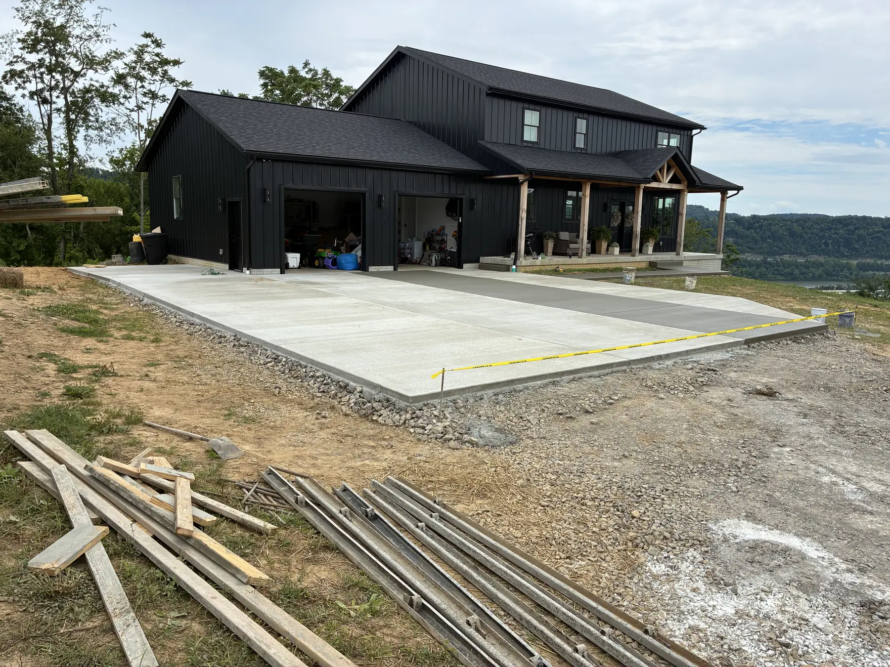 Large finished concrete driveway and parking area beside a home